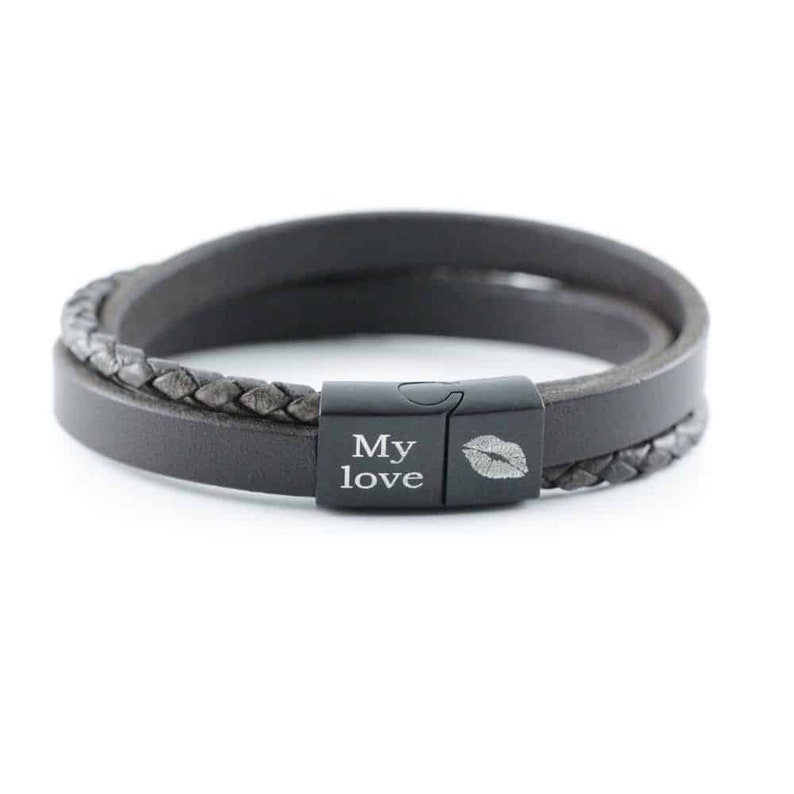 Puede incluir: Una pulsera de cuero gris oscuro con un dise&ntilde;o de doble hebra, que incluye una banda lisa y una banda trenzada. La pulsera cuenta con un cierre magn&eacute;tico de metal negro grabado con el texto My love y un gr&aacute;fico de labios.