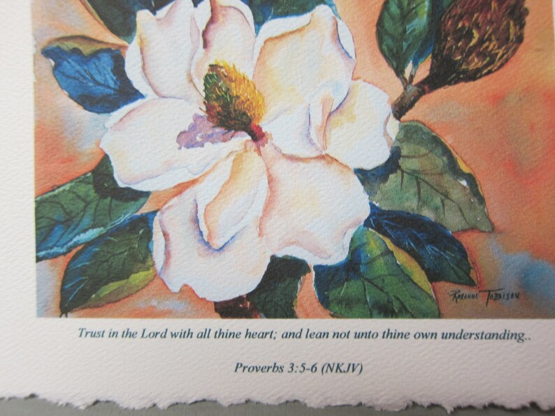 Peut inclure: Une peinture &agrave; l'aquarelle d'une fleur de magnolia blanche avec des feuilles vertes et un bourgeon brun. La peinture contient une citation de Proverbes 3:5-6 (NKJV) qui dit : "Fais confiance &agrave; l'&Eacute;ternel de tout ton c&oelig;ur, et ne t'appuie pas sur ta propre intelligence."