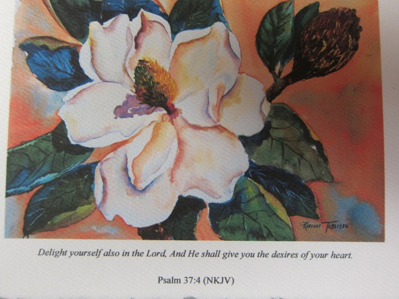 Peut inclure: Une peinture &agrave; l'aquarelle d'une fleur de magnolia blanche avec des feuilles vertes et un bourgeon brun. La peinture contient une citation de la Bible, Psaume 37:4 (NKJV) : "D&eacute;lecte-toi aussi en l'&Eacute;ternel, et il te donnera ce que ton c&oelig;ur d&eacute;sire."