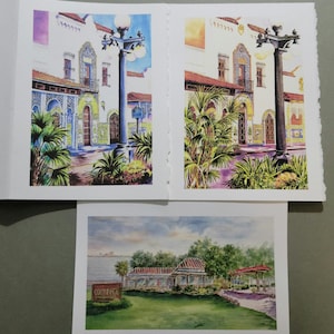 May include: Watercolor paintings of architectural scenes. One painting depicts a building with ornate details, a street lamp, and palm trees. Another shows a similar building. The third painting shows a building with the text "COLONNADE".