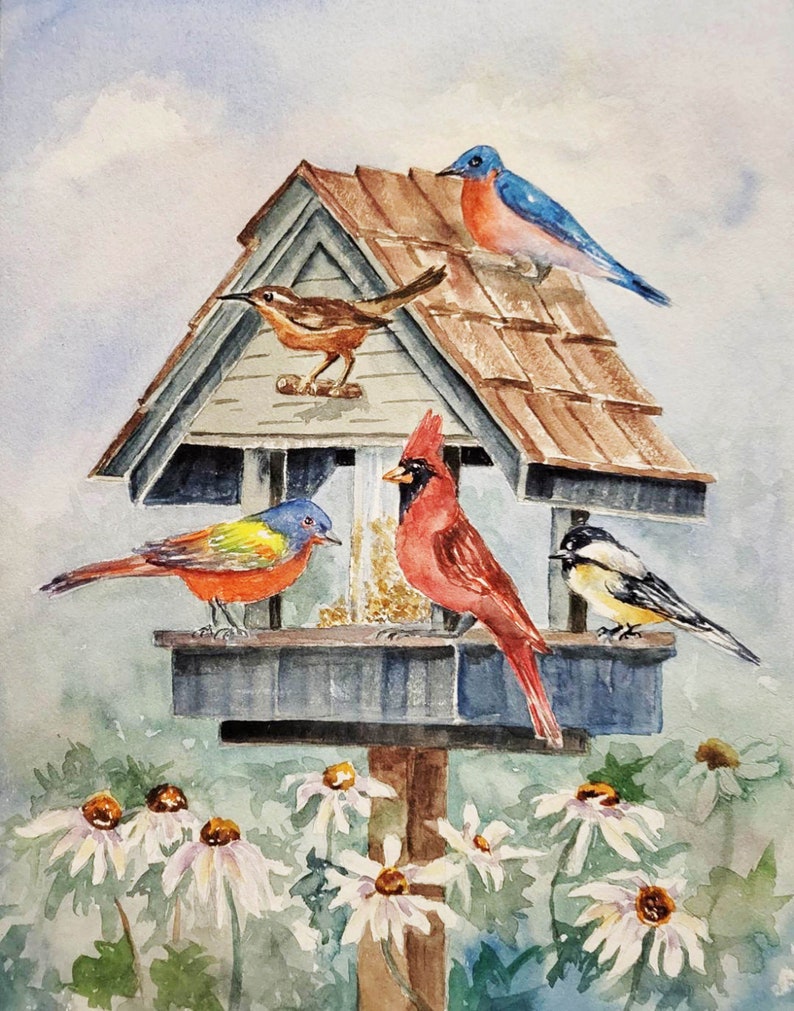 May include: A watercolor painting of a bird feeder with five birds. The feeder is a wooden structure with a brown roof and a blue base. The birds are a bluebird, a cardinal, a brown bird, a painted bunting, and a chickadee. The birds are perched on the feeder and eating seeds. The background is a light blue sky with white clouds and green foliage.