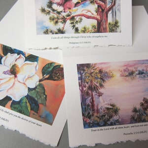 Peut inclure: Trois aquarelles avec des versets bibliques inspirants. La premi&egrave;re peinture montre une fleur de magnolia blanche avec des feuilles vertes. La deuxi&egrave;me peinture montre un oiseau perch&eacute; sur une branche d'arbre. La troisi&egrave;me peinture montre un lac avec des palmiers et un oiseau blanc.