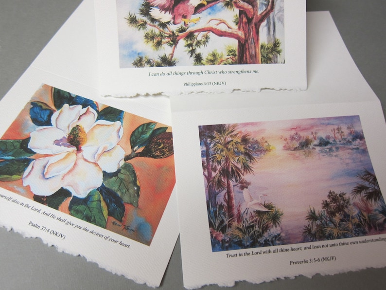 Peut inclure: Trois aquarelles avec des versets bibliques inspirants. La premi&egrave;re peinture montre une fleur de magnolia blanche avec des feuilles vertes. La deuxi&egrave;me peinture montre un oiseau perch&eacute; sur une branche d'arbre. La troisi&egrave;me peinture montre un lac avec des palmiers et un oiseau blanc.