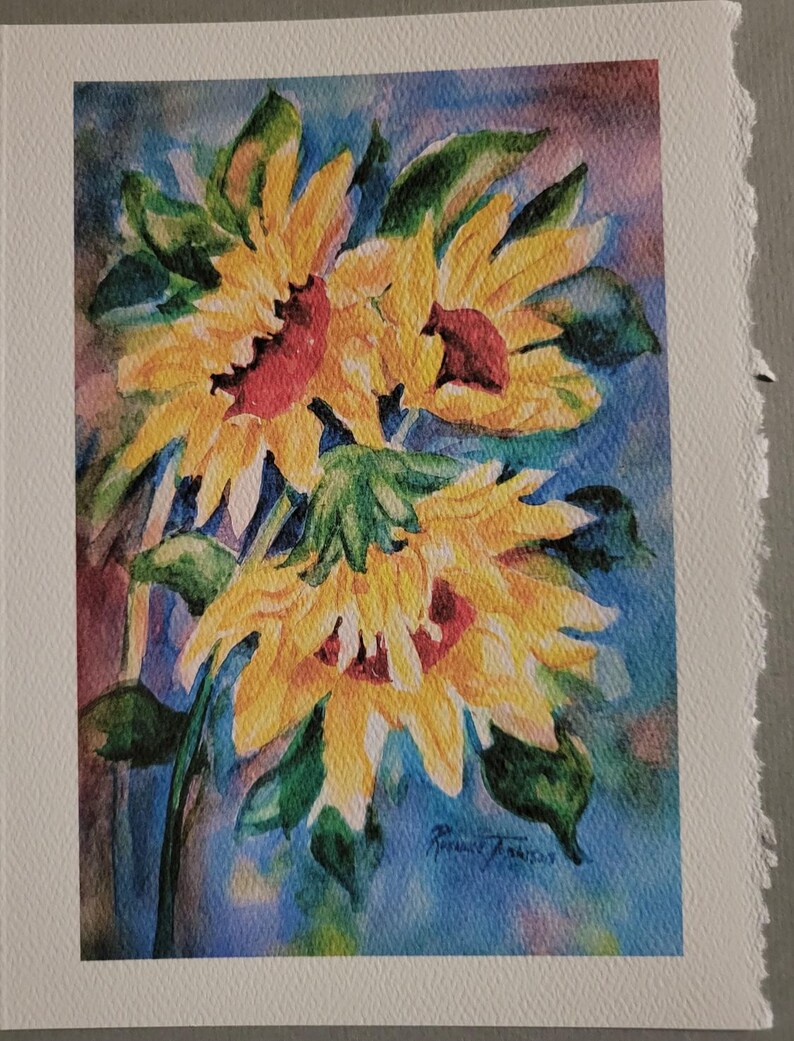 May include: Watercolor painting of three yellow sunflowers with red centers against a blue background.