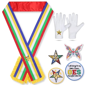 以下が含まれることがあります： 赤とマルチカラーのサッシュ、金色のフリンジ、星のエンブレムが付いた白い手袋、星とOESのロゴが刺繍されたさまざまなパッチなど、イースタン・スターのレガリアのコレクション。白い背景に表示されています。