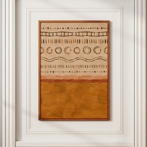Puede incluir: Una pieza de arte mural rectangular en un marco de madera que presenta una sección superior beige con filas horizontales de puntos, líneas, círculos y patrones ondulados de color marrón oscuro, sobre una sección inferior de color mostaza.