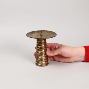 以下が含まれることがあります： 丸いトップとらせん状のベースを持つ金色の金属製のキャンドルホルダー
