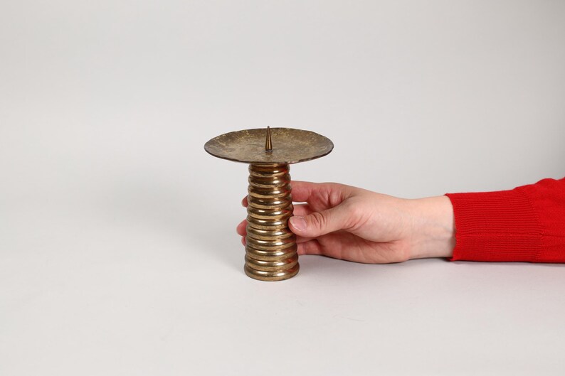 以下が含まれることがあります： 丸いトップとらせん状のベースを持つ金色の金属製のキャンドルホルダー