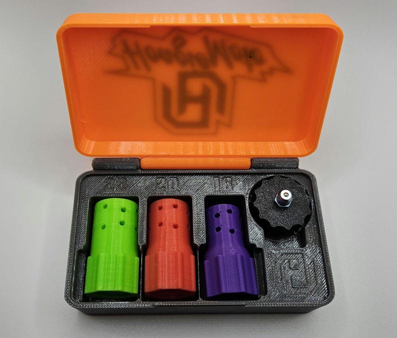 May include: An open orange and black case containing three multi-colored nozzles and a black knob. The nozzles are green, red, and purple. The case lid has the text "Hoop Hops" and a logo.