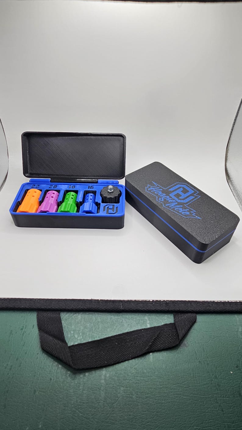 May include: A black and blue tool kit with a variety of colored attachments. The kit includes orange, purple, green, and blue pieces, along with a black piece. The lid of the kit has the text "House Moto" in blue.