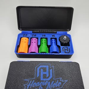 May include: A black case with a blue interior holds various colored tools. The tools are orange, purple, green, and blue, with numbers 22, 20, 18, and 16 above them. The case also contains a black component. The bottom case has the text "Hoagie Moto".