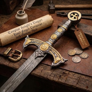 May include: A detailed image of a Templar Knight's dagger with a Damascus blade. The hilt is ornate with gold and silver accents, and a cross design. A scroll with text and a leather tag are also present.