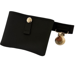 May include: Black faux leather fanny pack with a gold-colored metal clasp and button closure. The small pouch has a textured surface and a black elastic strap.