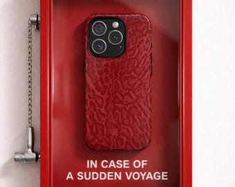 Può includere: Custodia per telefono rossa con motivo strutturato, esposta all'interno di una scatola rossa con la scritta "BREAK GLASS" e "IN CASE OF A SUDDEN VOYAGE". La custodia ha più obiettivi della fotocamera. L'handle del marchio è visualizzato in basso.