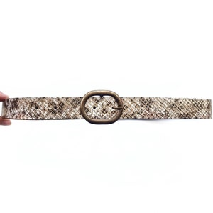 May include: A brown snakeskin belt with a gold oval buckle.