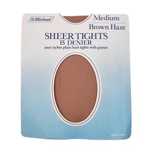 May include: A packaging label for sheer tights in medium size, brown haze colour, 15 denier, made of 100% nylon, with a gusset. The label features a brown swatch of the tights.