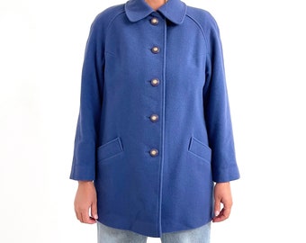 May include: A blue wool coat with a collar and button fastening. The coat has two pockets on the front and is lined with a contrasting fabric.