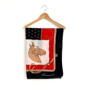 May include: A black silk scarf with a red, white, and gold design featuring a horse's head and the word "Leonard" in cursive.