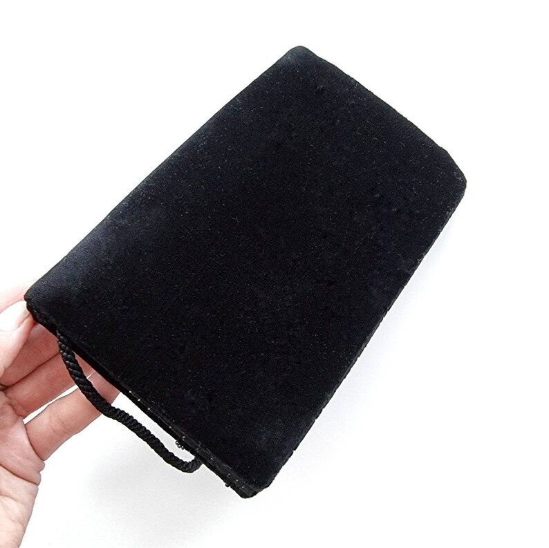 May include: A black velvet clutch bag with a short strap.