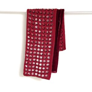 May include: A burgundy velvet scarf with a pattern of white circles. The scarf is folded and hanging on a white rod.