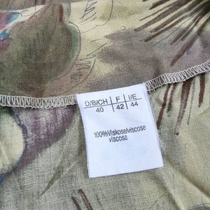 May include: White tag with black text indicating size in D/B/ICH, F, and IT sizing. The tag also states "100% Viskose/Viscose Viscosa".