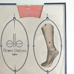 May include: A package for a pair of pink Elle tights with a floral pattern. The package has a small sample of the tights and the text "Elle Flower Pattern tights" on the front.