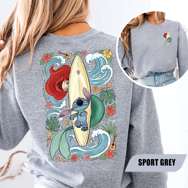 May include: A sport grey crewneck sweatshirt featuring a large back graphic of Stitch lying on a yellow surfboard with Ariel, surrounded by blue ocean waves, tropical flowers, green leaves, seashells, and a small ukulele. A small matching graphic is on the front.
