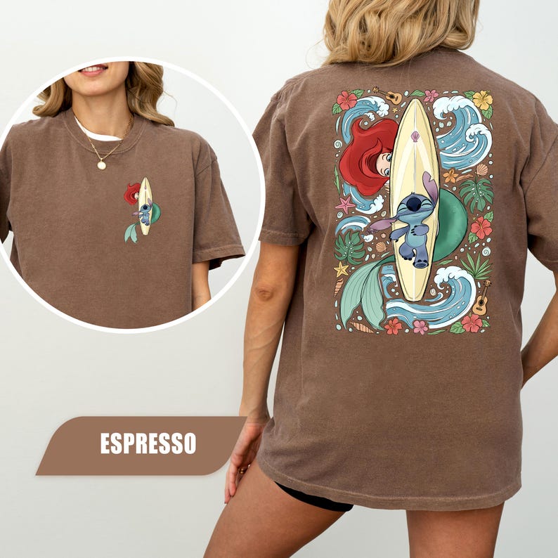 May include: A brown t-shirt featuring a graphic of Stitch on a surfboard with Ariel, surrounded by ocean waves, tropical flowers, and a ukulele. The front chest displays a smaller version of the same graphic, and the color is labeled as espresso.