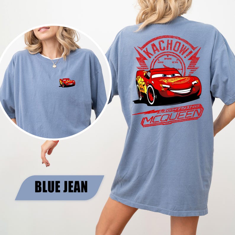 May include: A blue jean colored t-shirt featuring a small Lightning McQueen graphic on the front left chest and a large graphic on the back displaying Lightning McQueen, a speedometer, the text KACHOW!, and the name LIGHTNING MCQUEEN.