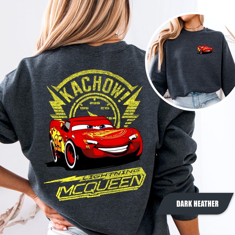 May include: A dark heather gray sweatshirt featuring a large graphic on the back of the red race car Lightning McQueen with the text KACHOW and LIGHTNING MCQUEEN in yellow. A smaller version of the red race car is printed on the front left chest.