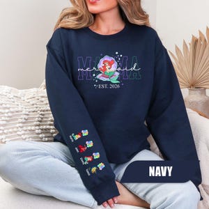 May include: A white ceramic mug with a black handle and the text "But First, Coffee" in a bold, black font. The mug is sitting on a wooden surface. The mug is 4 inches tall.