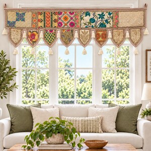 May include: A rectangular window valance featuring a patchwork of embroidered fabric panels in gold, pink, orange, and teal. The bottom edge has scalloped points, each finished with a cream-colored tassel, and additional tassels hang between.