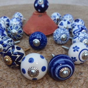 May include: A white ceramic mug with a black handle and the text "But First, Coffee" in a black, handwritten-style font. The mug is on a white surface.