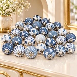 Diverse keramische ladeknopjes, set van 4, grijs, blauw en wit met bloemenmotief, decoratieve handgrepen voor keukenkastjes en dressoirs.