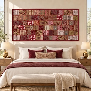 Puede incluir: Un gran tapiz rectangular con un diseño de patchwork compuesto por cuadrados de tela en tonos rojos, burdeos y dorados con bordados intrincados, motivos florales y patrones geométricos, enmarcado por un borde rojo oscuro.