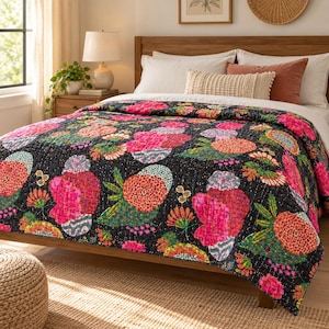 May include: A quilted bedspread featuring a dark background with a vibrant floral pattern in shades of pink, orange, and green. The quilt is draped over a bed with white pillows and a textured lumbar pillow, showcasing detailed stitching.