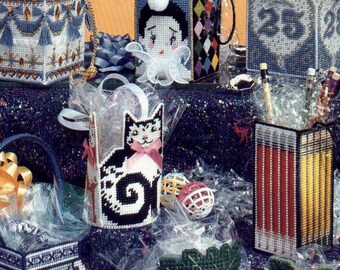 May include: A collection of handmade plastic canvas gift baskets in various shapes and designs. The baskets feature floral, geometric, and character patterns, with some including handles and decorative elements. The cover also includes the text "Gift Baskets".