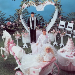 Pode incluir: Um kit de artesanato em tela de plástico intitulado "Fairy Tale Wedding" com uma noiva boneca em uma carruagem puxada por um cavalo branco. A cena inclui um noivo, bolo de casamento e arco em forma de coração, tudo em tons pastel.