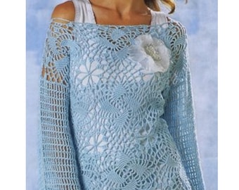 Può includere: Un top in crochet azzurro chiaro con un delicato motivo floreale. Il top ha una scollatura ampia e aperta e maniche lunghe. Una spilla a forma di fiore bianco è appuntata sulla parte anteriore del top.