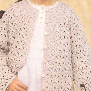 May include: A crocheted cardigan with a button-up front. The cardigan is made with a delicate open stitch pattern and is a light beige color.