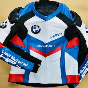 May include: A motorcycle jacket in white, blue, black, and red, featuring the BMW logo and "HP4" text. The jacket has padded shoulders and elbows, with "BMW Motorrad" printed on the sleeves. The jacket is made of leather.