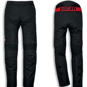 May include: Black motorcycle trousers with reinforced knee and seat panels. The trousers have multiple pockets, zippers, and a red Ducati logo. The back features a red waistband with the Ducati brand name in white.