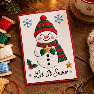 Peut inclure: Une carte de vœux blanche à bordure rouge ornée d'un bonhomme de neige brodé portant un bonnet et une écharpe rayés rouge et vert, tenant une étoile jaune. Le texte Let It Snow est brodé en noir, entouré de flocons bleus, de houx et d'une étoile.