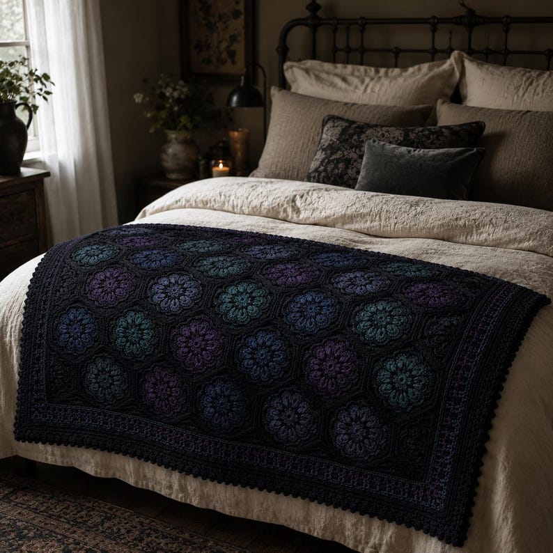 May include: A rectangular crochet blanket featuring a repeating hexagonal floral motif in shades of deep purple, teal, and black. The blanket has a solid black border with a scalloped edge, showcasing intricate yarn work and a textured surface.