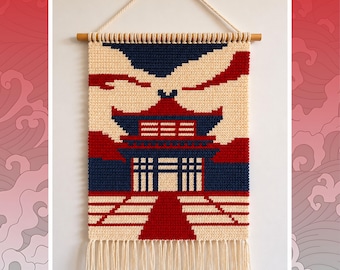 Puede incluir: Un tapiz de ganchillo rectangular con un diseño de templo en hilo color crema, azul marino y rojo. La pieza está suspendida de un palo de madera con un cordón crema y terminada con un fleco de borlas de hilo crema en el borde inferior.