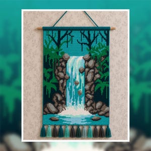 May include: A rectangular wall hanging featuring a cross-stitch pattern of a waterfall cascading over brown rocks into a blue pool. The scene includes dark green trees and foliage. It is suspended from a wooden rod with a teal cord and teal tassels.