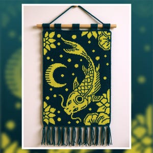 May include: A dark teal wall hanging with a yellow koi fish design, a crescent moon, and floral accents. The tapestry is rectangular, with a fringe at the bottom and a wooden rod at the top for hanging. The design is a mix of geometric and organic shapes.