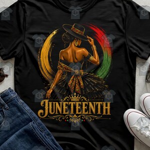 May include: A black t-shirt featuring a graphic of a person wearing a wide-brimmed hat and a ruffled dress with patterned accents. The design includes a circular yellow, red, and green brushstroke background and the gold text JUNETEENTH.