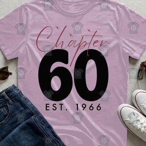 May include: A light purple short-sleeved t-shirt featuring the text "Chapter 60" in a dark script and bold sans-serif font, with the text "EST. 1966" printed below in black. The design includes small star accents above the word Chapter.