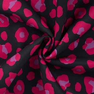Könnte beinhalten: Schwarzer Stoff mit einem auffälligen Leopardenmuster. Das Design zeigt große, unregelmäßige Flecken in leuchtendem Fuchsia-Pink und sanfteren Lavendeltönen. Der Stoff ist gerafft, was seine Textur und seinen Fall zeigt.